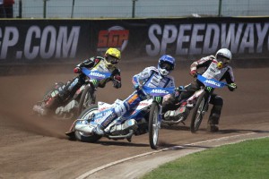 Nicki Pedersen vede před Chrisem Harrisem (žlutá) a Maciejem Janowskim (bílá)