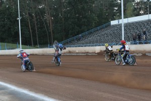 Zatímco Filip Hájek (modrá) krotí svůj motocykl a Josef Novák (červená) se mu snaží vyhnout, Martin Málek (žlutá) a Michael Hádek (bílá) letí dopředu